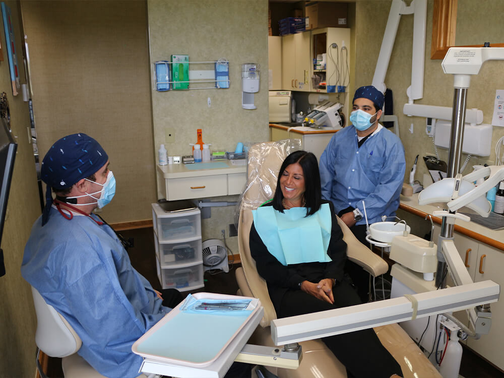 Dr Scott Harris sits next to a dental patient during their visit to Harris Dentistry in Boca Raton, FL