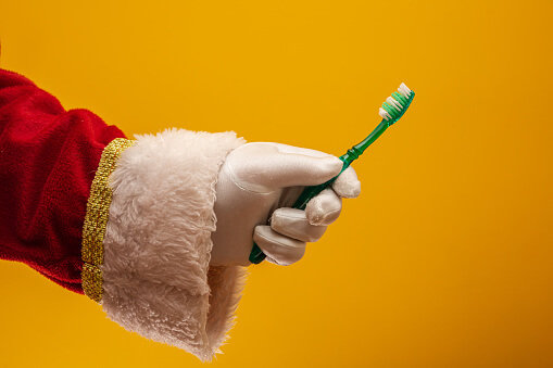 Santa hand holding toothbrush